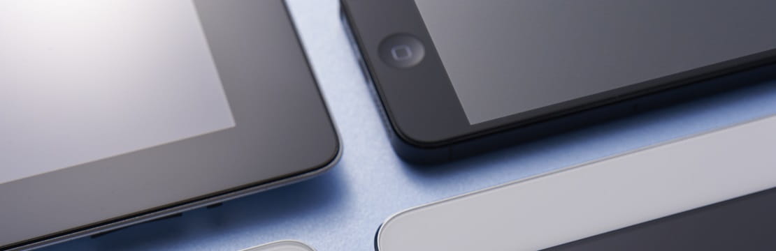 Collection of smartphones and tablets laying in a grid pattern